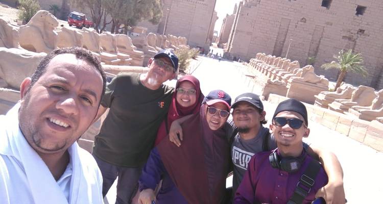 Groepsfoto voor een oude tempel met beelden.