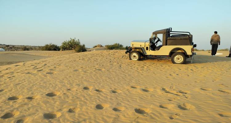 Desert safari with a jeep in sandy dunes.