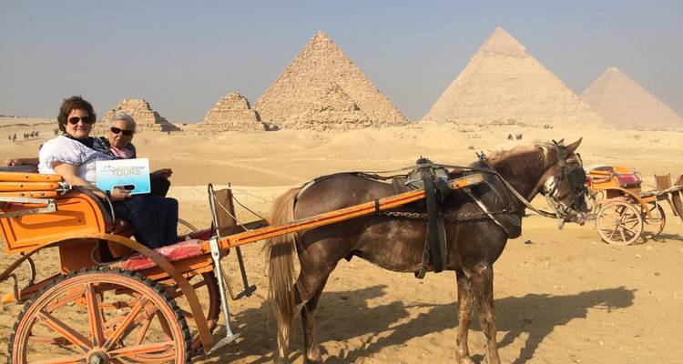 Een paardenkoets met twee mensen voor de piramides.