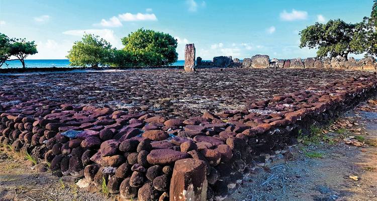 Site historique avec structures en pierre près d'une côte.