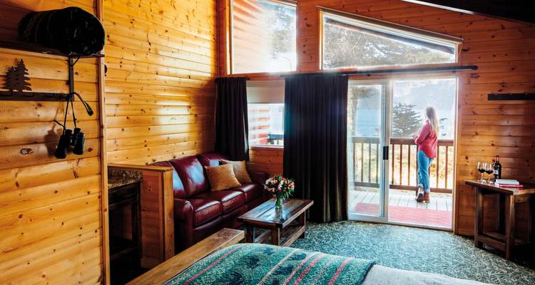 Hüttenzimmer mit Holzinterieur und Bergblick vom Balkon.
