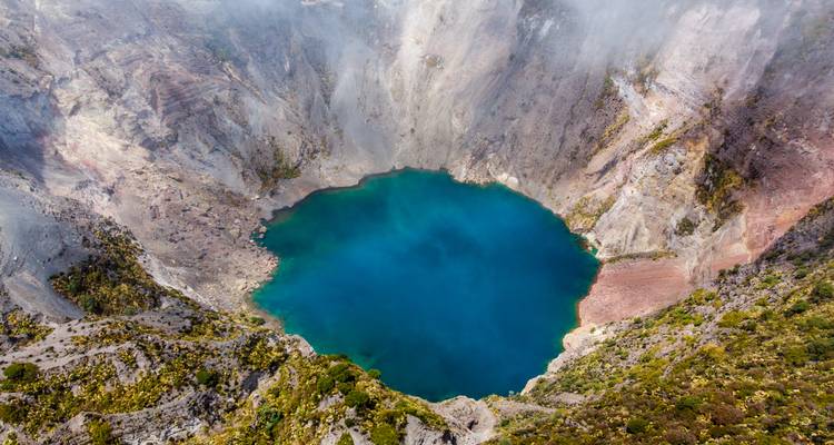 Kratersee mit tiefblauem Wasser, umgeben von Klippen.