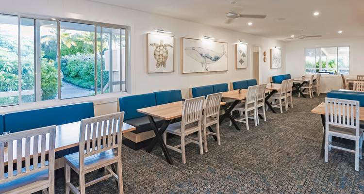 Dining area with tables and chairs in a hotel.