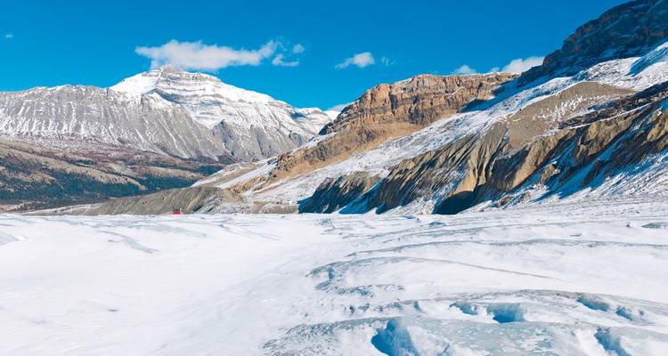 A snowy mountainous landscape with a frozen river.
