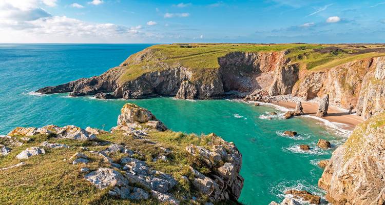Paysage côtier avec des falaises escarpées et des eaux turquoise.