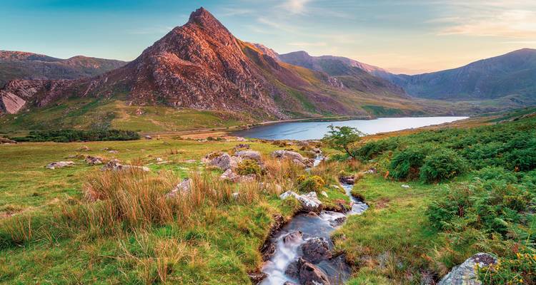 Paysage montagnard idyllique avec un ruisseau qui coule à travers.