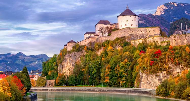 Burgfestung auf einem Hügel mit Herbstlaub.
