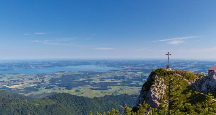 Vue panoramique depuis un sommet de montagne avec une croix.