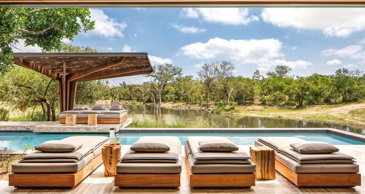 Espace de détente extérieur au bord d'une piscine avec vue panoramique.
