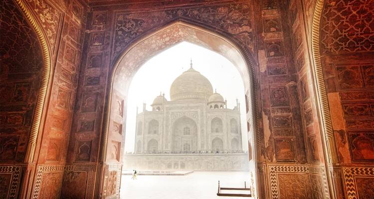 Vue du Taj Mahal à travers une arche décorative.