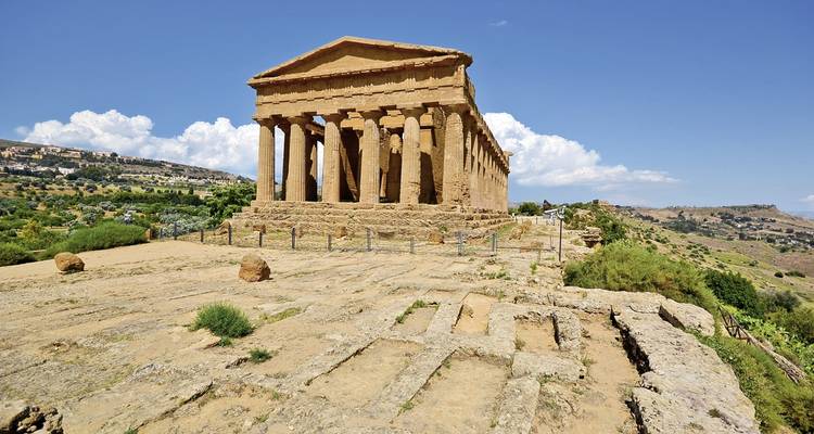 Tempel im altgriechischen Stil, umgeben von einer malerischen Landschaft.