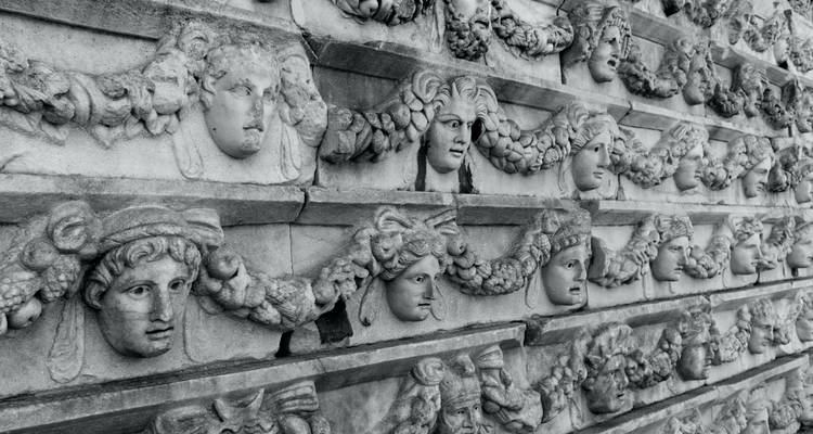 Anciennes sculptures sur pierre avec des visages humains.