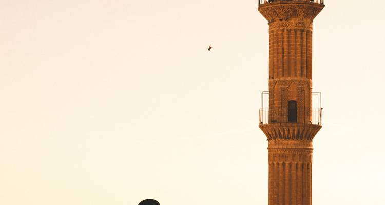Silhouette de minaret contre un ciel dégagé.
