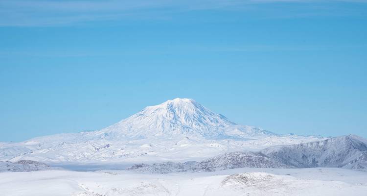 Montagne enneigée contre un ciel dégagé.