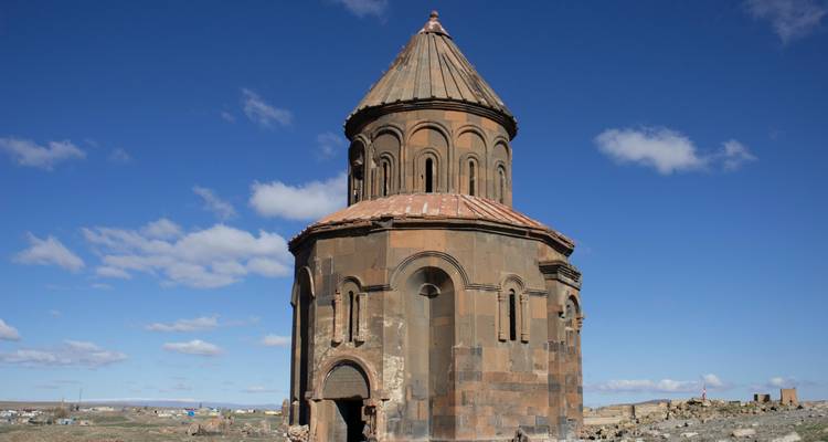 Tour ronde historique sur une colline sous un ciel bleu.