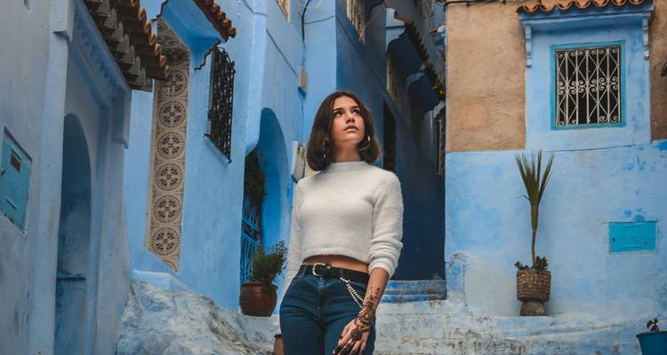 Femme marchant dans une rue peinte en bleu.