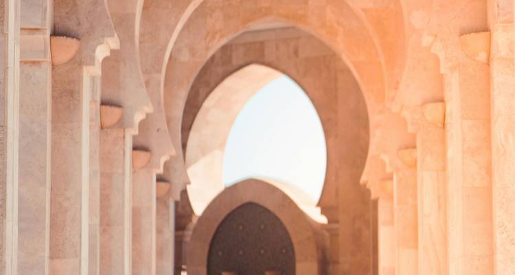 Vue à travers les arcs d'un bâtiment traditionnel marocain.