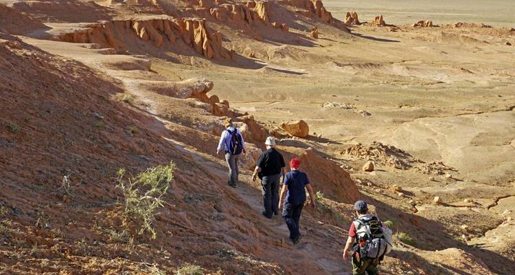 People hiking in a rocky desert landscape.