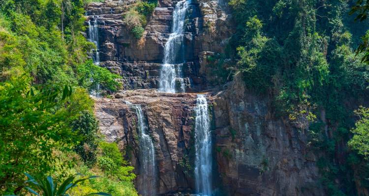 Tropische waterval omgeven door vegetatie.