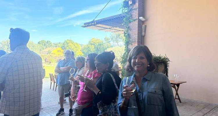 Des personnes dégustant un verre de vin dans un cadre extérieur.