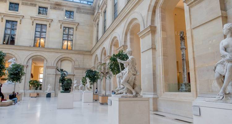 Intérieur d'un musée avec des sculptures et de la verdure.