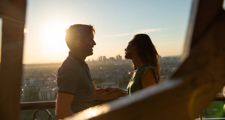 Silhouette d'un couple avec vue sur la ville au coucher du soleil.