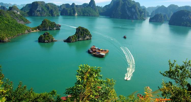 Aerial view of boats navigating through the emerald waters of Halong Bay.