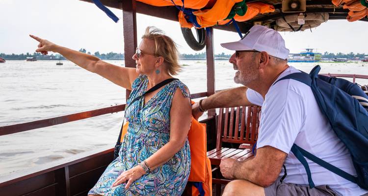 Des touristes sur un bateau profitant d'une vue panoramique sur la rivière.