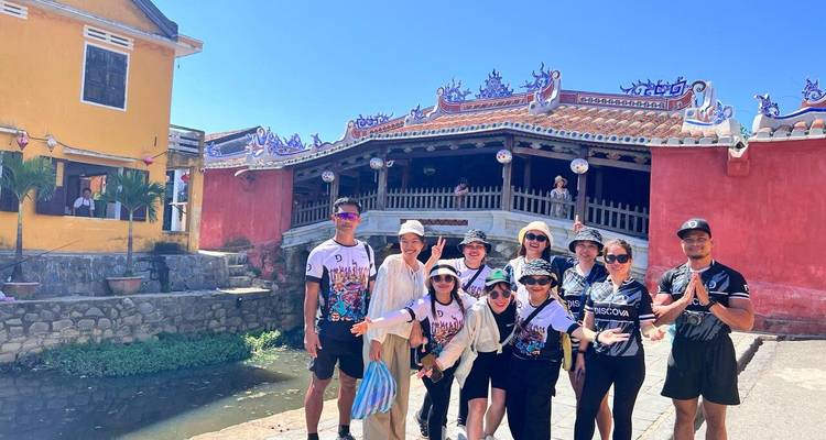 Groupe de touristes devant un pont coloré.