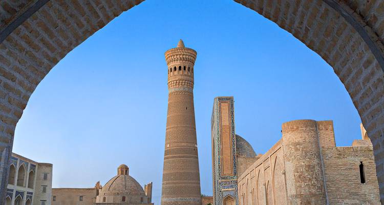 Ein hoch aufragender Minarett mit kunstvoller Architektur unter einem blauen Himmel.
