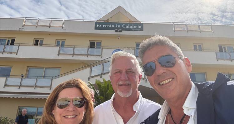 Drie mensen die een selfie maken voor een gebouw.