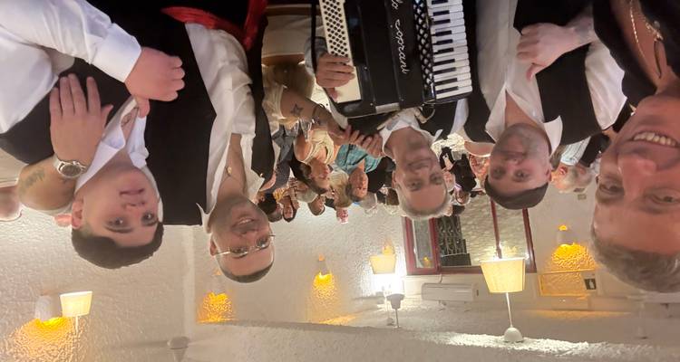 Een groep mensen die binnen poseert met een accordeon.