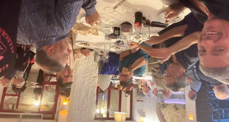 Mensen die dineren in een restaurant met anderen op de achtergrond.