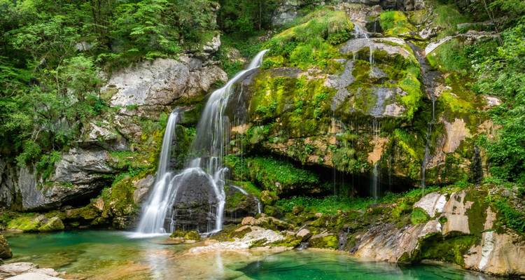 Cascade d'eau qui dévale sur des rochers couverts de mousse en Slovénie.
