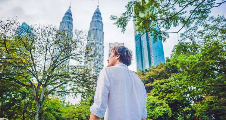 Ein Mann, der die Petronas Towers in Kuala Lumpur betrachtet.