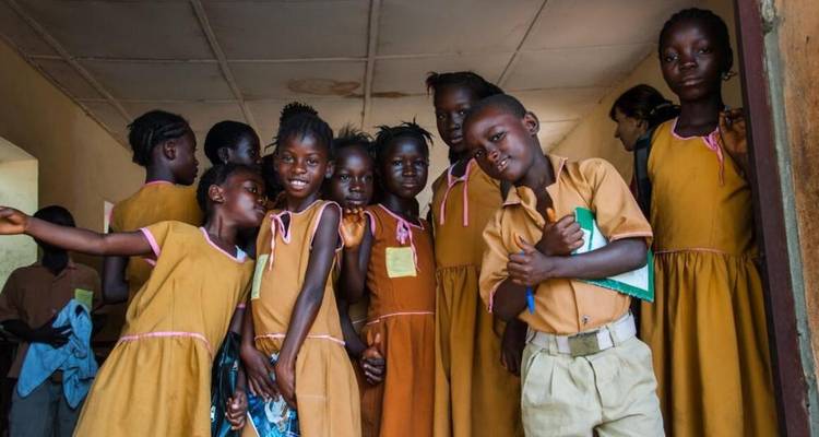 Groupe d'enfants en uniforme scolaire dans un couloir.