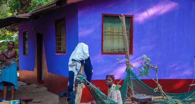 Deux femmes devant une maison aux couleurs vives.