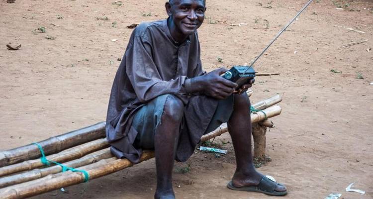 Homme assis dehors avec une radio.