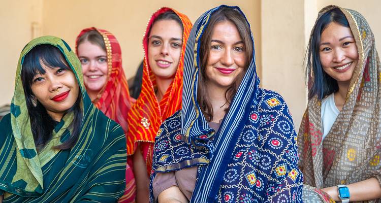 Vrouwen in kleurrijke sari's poseren samen.