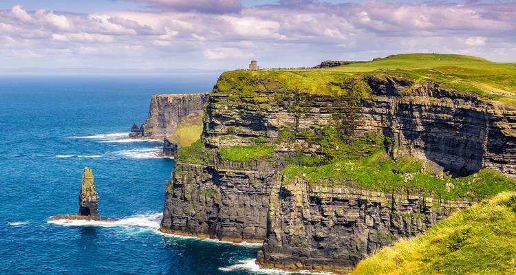 De Cliffs of Moher die uitkijken over de oceaan met een heldere hemel.