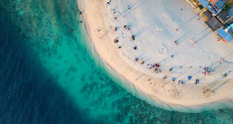 Vue aérienne d'une plage immaculée aux eaux turquoise.