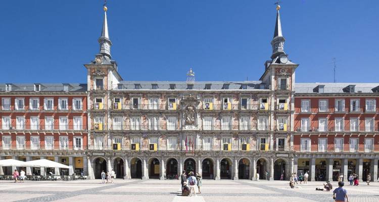 Bulliciosa Plaza Mayor en Madrid capturada bajo un cielo azul brillante