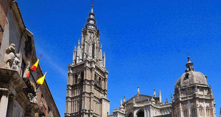 Torre alta y cúpulas de la Catedral de Toledo elevándose contra un cielo azul vívido