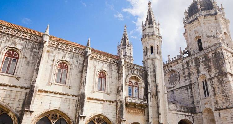Detalle del Monasterio de los Jerónimos de Lisboa con intrincados tallados en piedra bajo un cielo parcialmente nublado