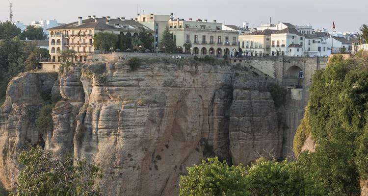 Edificios históricos encaramados en la cima de los espectaculares acantilados de Ronda con un profundo desfiladero abajo