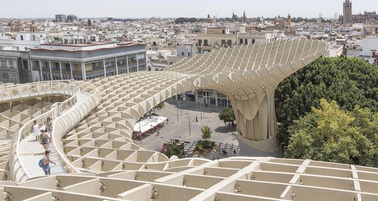 Estructura arquitectónica moderna que se asemeja a un dosel con visitantes.