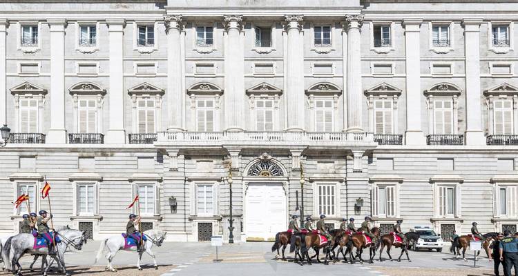 Gardes royaux à cheval devant un bâtiment de palais.