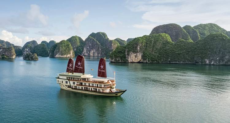 Kreuzfahrtschiff, das in unberührten Gewässern fährt, umgeben von dramatischen Klippen.