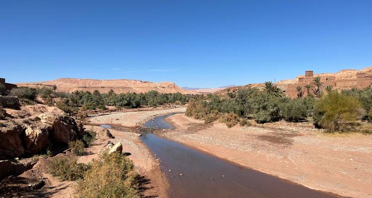 A sparse river landscape with arid terrain and greenery.
