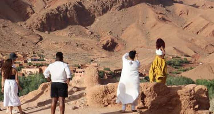 Group of people exploring rocky desert terrain.
